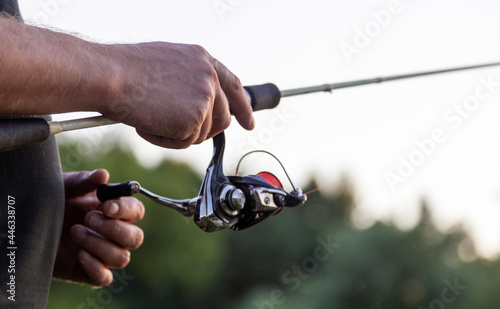 Active life on fishing. The fisherman holds a light spinning in his hand. Suburban recreation, sport fishing.