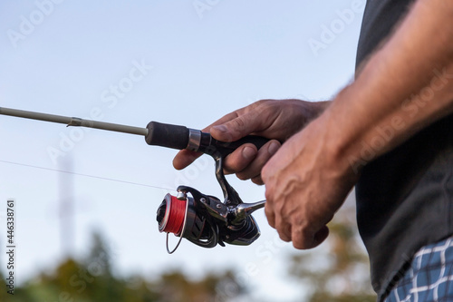 Close up. The fisherman holds a spinning in his hand, and catches fish, sport fishing.