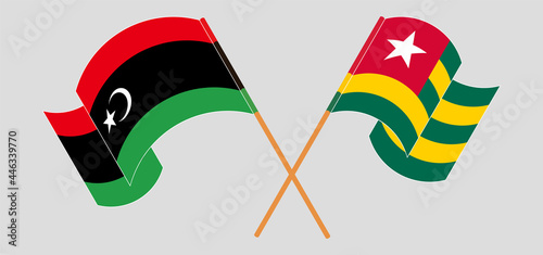 Crossed and waving flags of Libya and Togo