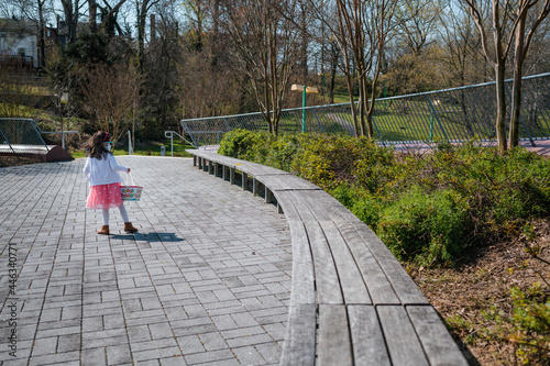 Young girl on Easter egg hunt in outdoor park photo