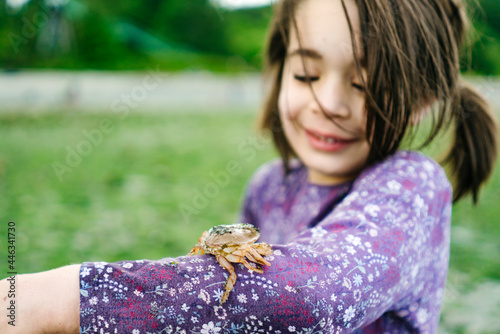 Closeup image of a shore crab on a child's arm