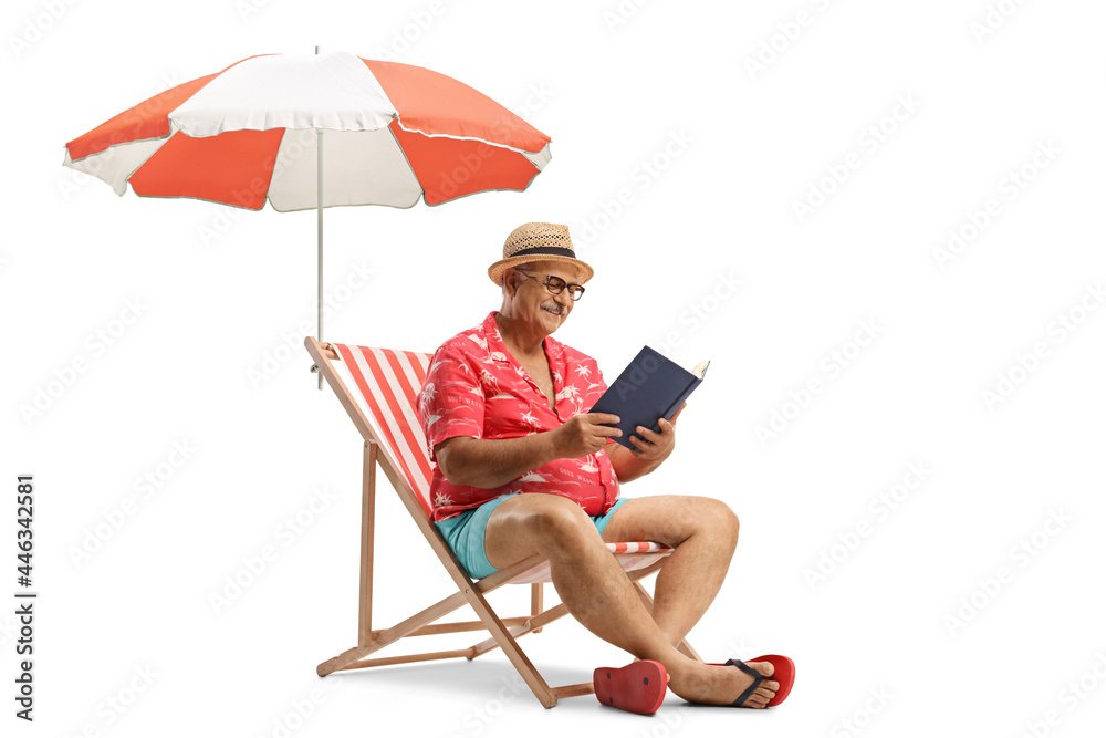 Man with a book sitting in a bech chair and reading under umbrella