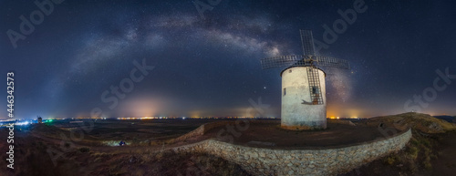 Milky way arched over old windmill nightscape with stars photo