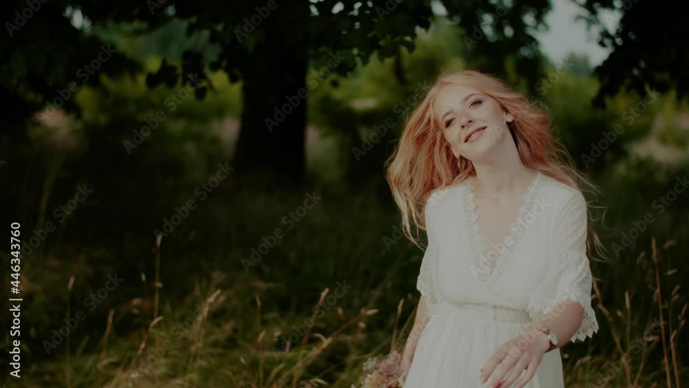Carefree Boho Woman Walking and Smiling on a Meadow in Summer Carefree Boho Woman Walking and Smiling on a Meadow in Summer