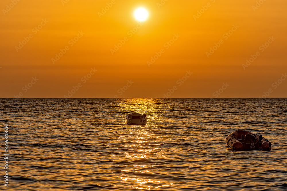Utjeha, Montenegro - July 07, 2021: A boat at sunrise on the Adriatic Sea Utjeha, Montenegro - July 07, 2021: A boat at sunrise on the Adriatic Sea