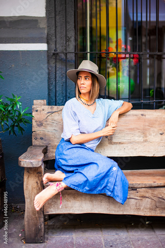 beautiful Mexican woman sitting on a bench photo