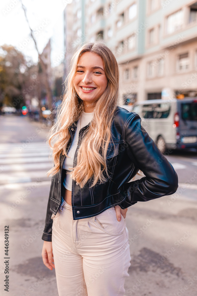 Portrait of smiling millennial woman on the street