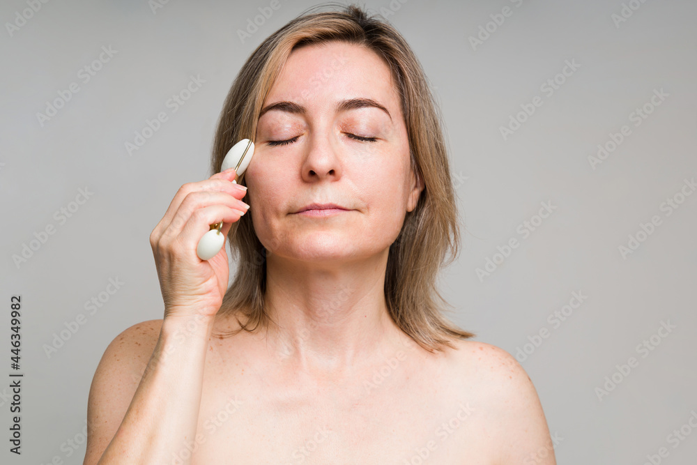 Relaxed older woman massaging her face Relaxed older woman massaging her face