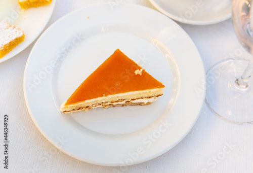 Slice of delicious classical cheesecake with fruity sauce served in cafeteria photo