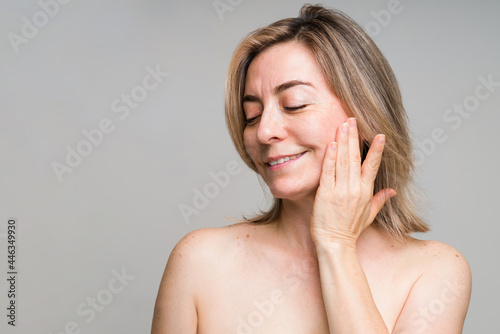 Older woman touching her smooth skin