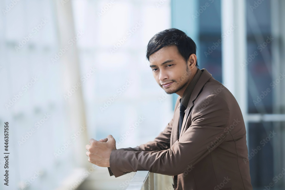 Businessman in brown suit. Thinking. Company background. Glass building. Businessman in brown suit. Thinking. Company background. Glass building.