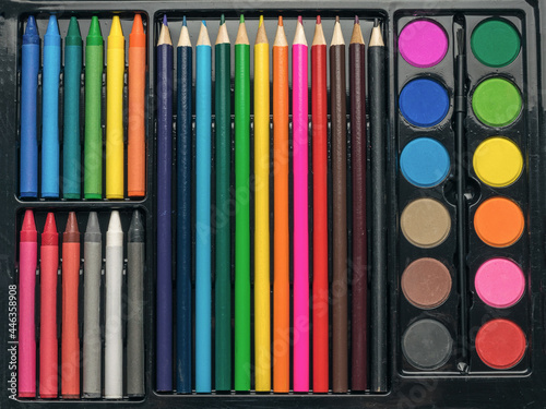 Artist's set of paints, crayons and pencils close-up.