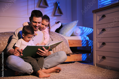 Father reading bedtime story to his children at home
