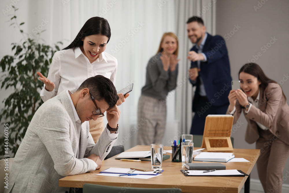 Woman scolding employee at workplace in office