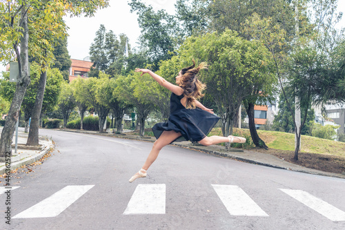 Ballet dancer running and dancing across a crosswalk on a street