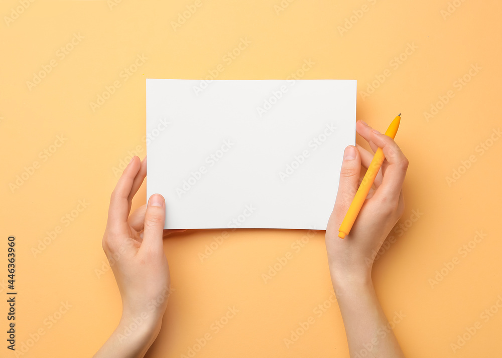 Woman holding blank sheet of paper and pen on color background Woman holding blank sheet of paper and pen on color background