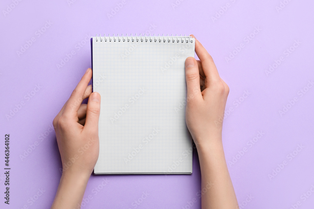 Obraz premium Woman holding blank notebook on color background, closeup