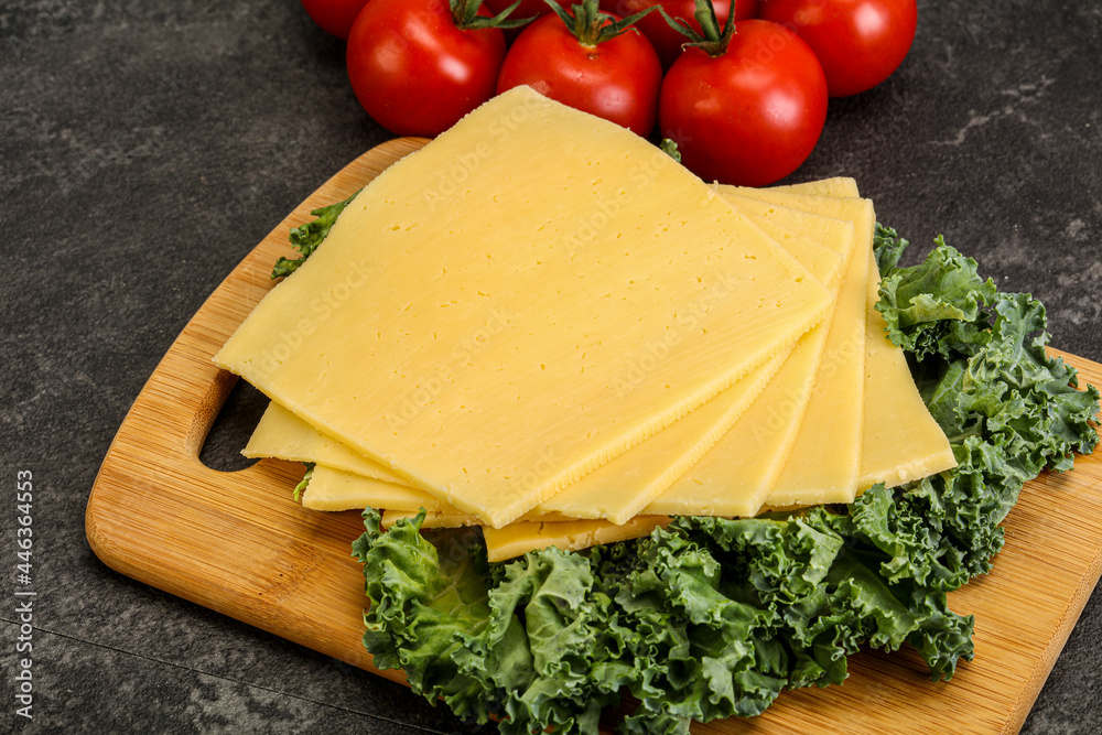 Sliced Gauda cheese over board Sliced Gauda cheese over board
