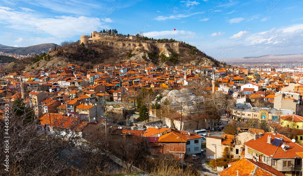 Scenic view of residential districts of Turkish city of Kutahya on background of hill with ruined Byzantine castle on top on sunny winter day