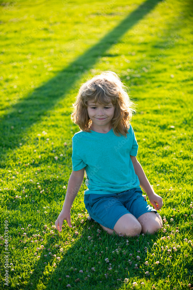 Fototapeta premium Beautiful boy at the park looking happy. Summer kid.