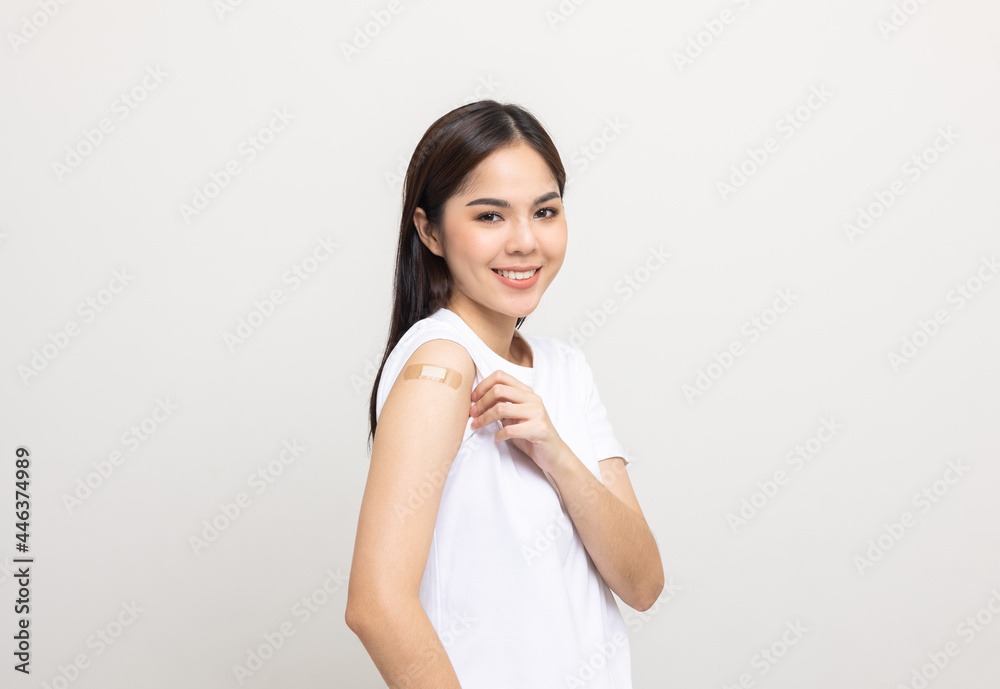 Vaccination. Young beautiful asian woman getting a vaccine protection the coronavirus. Smiling happy female showing arm with bandage after receiving vaccination. On isolated white background. Vaccination. Young beautiful asian woman getting a vaccine protection the coronavirus. Smiling happy female showing arm with bandage after receiving vaccination. On isolated white background.