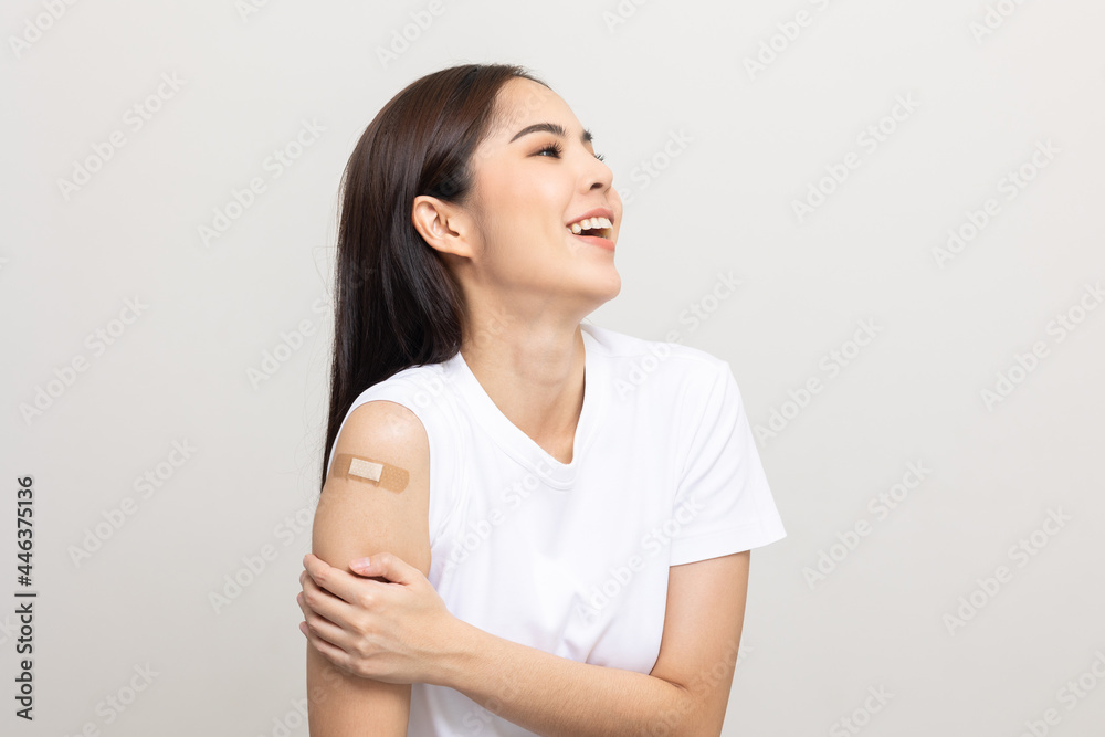 Vaccination. Young beautiful asian woman getting a vaccine protection the coronavirus. Smiling happy female showing arm with bandage after receiving vaccination. On isolated white background. Vaccination. Young beautiful asian woman getting a vaccine protection the coronavirus. Smiling happy female showing arm with bandage after receiving vaccination. On isolated white background.