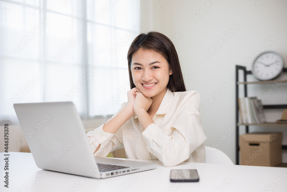 Young asian beautiful business woman working with laptop sitting at home. Smiling charming happy young female doing homework meeting conference with team at home. Young asian beautiful business woman working with laptop sitting at home. Smiling charming happy young female doing homework meeting conference with team at home.