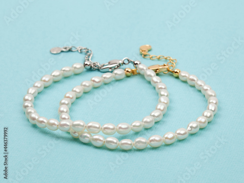 Luxury elegant baroque pearl bracelets on bright turquoise textured background