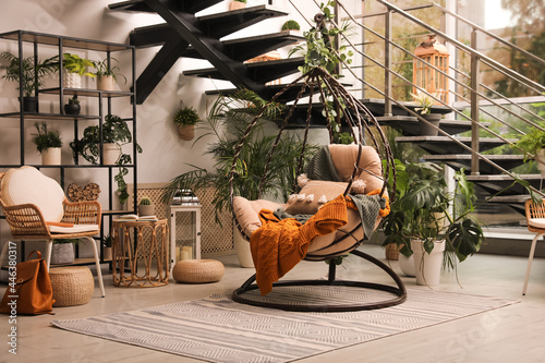 Indoor terrace interior with hanging chair and green plants photo