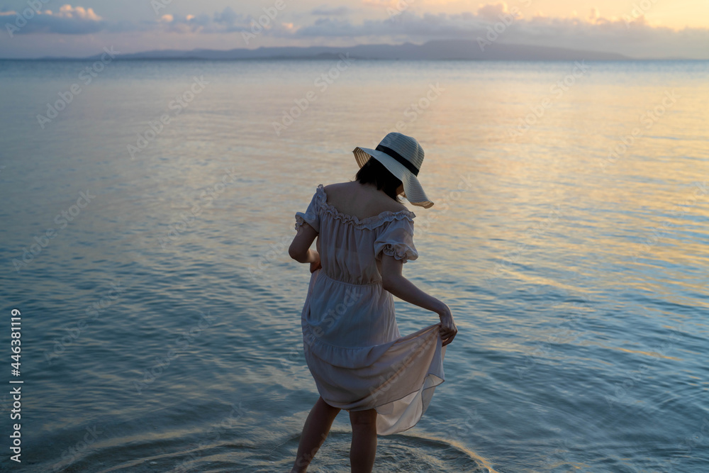 石垣島の夕日のビーチに女性がいる風景 沖縄 