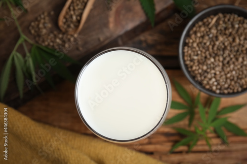 Glass of fresh hemp milk on wooden table, top view
