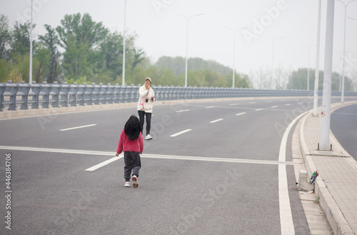 Mom and daughter fly a kite on the highway
