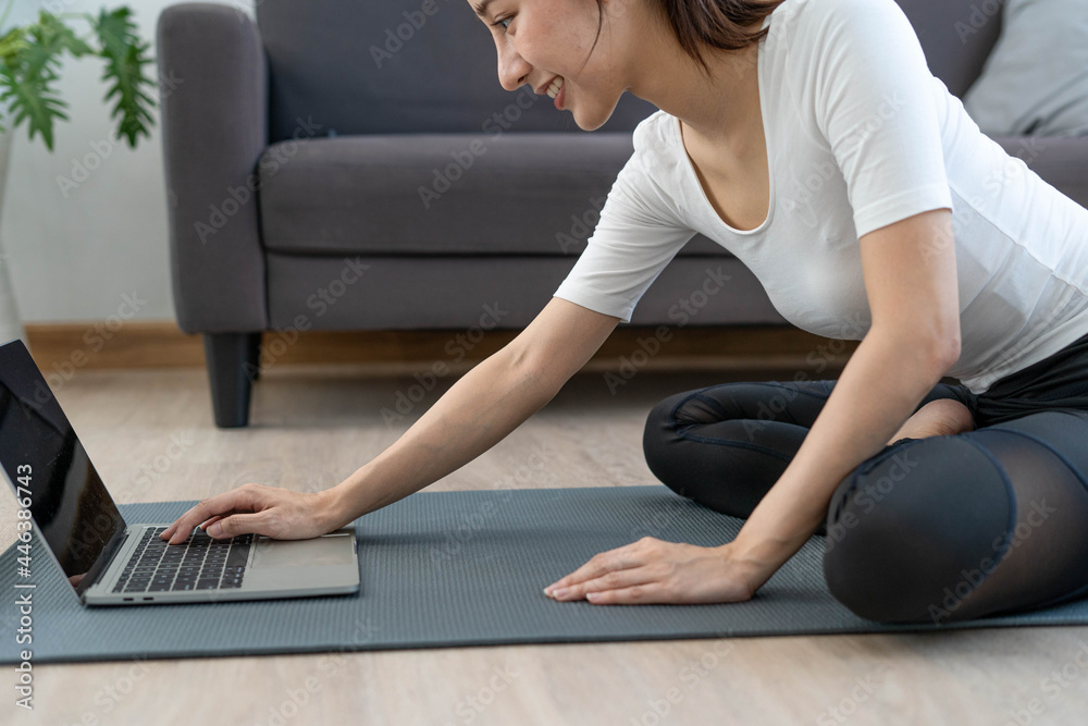 A good-looking female teacher uses a laptop camera to teach online exercises. women exercising at home with friends on the internet