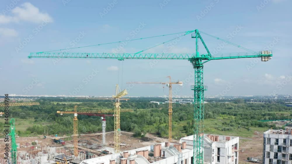 Aerial Flight Over a New Constructions Development Site with High Tower Cranes Building Real Estate. Heavy Machinery and Construction Workers are Employed. Urban Construction Site, Aerial View Aerial Flight Over a New Constructions Development Site with High Tower Cranes Building Real Estate. Heavy Machinery and Construction Workers are Employed. Urban Construction Site, Aerial View
