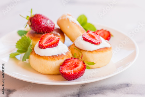 Sweet cheese pancakes on plate served strawberries and mint. Cottage cheese pancakes  syrniki  ricotta fritters  curd fritters.