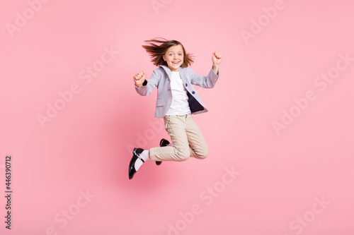 Full body photo of hooray small girl jump wear blazer trousers shoes isolated on pastel pink color background