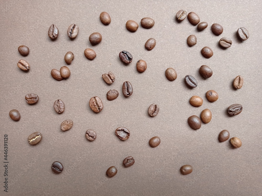 Coffee beans on a brown background, pattern. Coffee varieties, roasting, coffee making. The backdrop. Coffee beans on a brown background, pattern. Coffee varieties, roasting, coffee making. The backdrop.