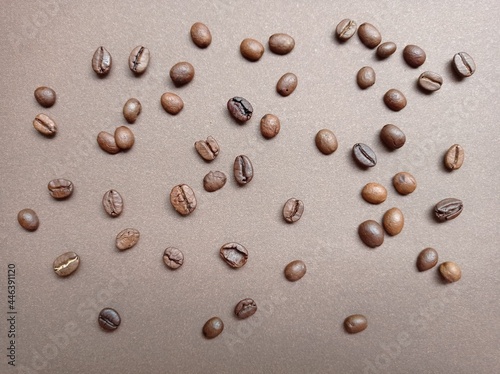 Coffee beans on a brown background, pattern. Coffee varieties, roasting, coffee making. The backdrop.