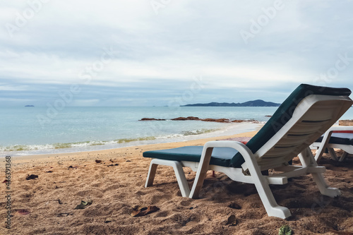 Empty long chair for relaxing on the sand. Tropical beach waiting for tourists in summer. The tourism industry awaits the arrival of travelers. Natural landscape background. © Win Nondakowit