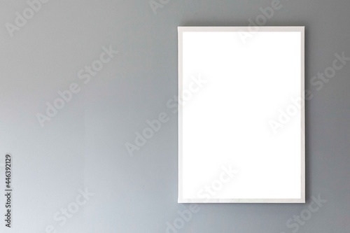 Blank white photo frame on a smooth gray wall