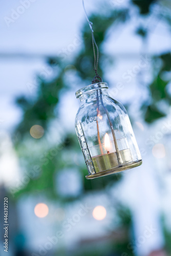 hanging bottle with candle for garden lighting © Luca