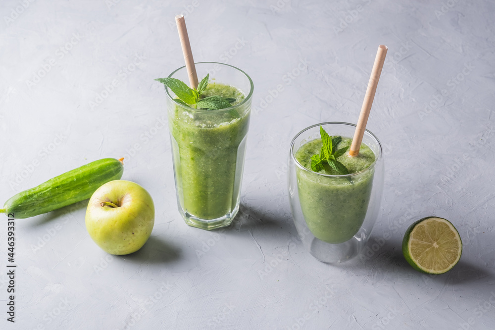 Fototapeta premium Fresh green smoothie in glass on wooden table, closeup. Detox diet concept: green vegetables on rustic table. Clean eating, alkaline diet, weight loss food concept.