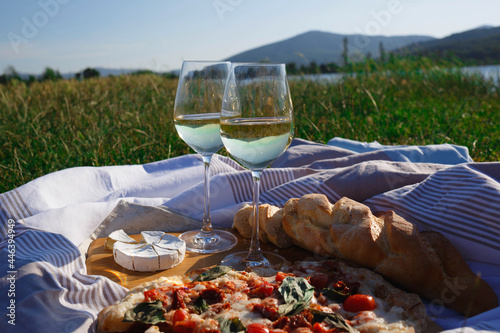picnic in nature: pizza, cheese, baguette and glasses of wine