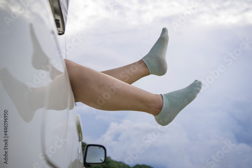 Feet of a asian girl in warm socks from the window of a car. Little holiday trip.