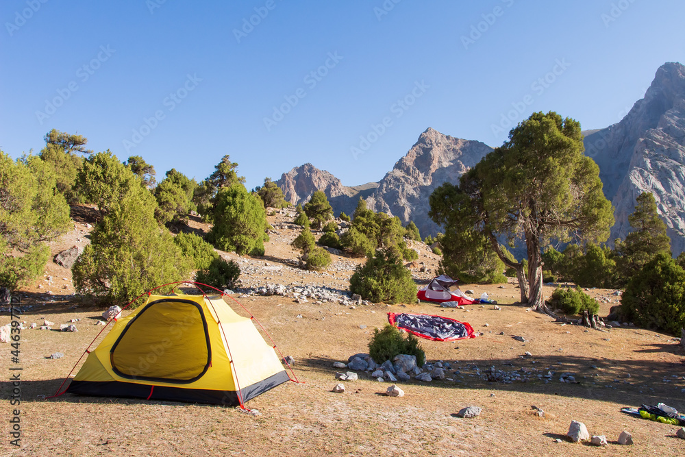 Camping in mountains. Setting tents for the night. Traveling with a group in Fann mountains.