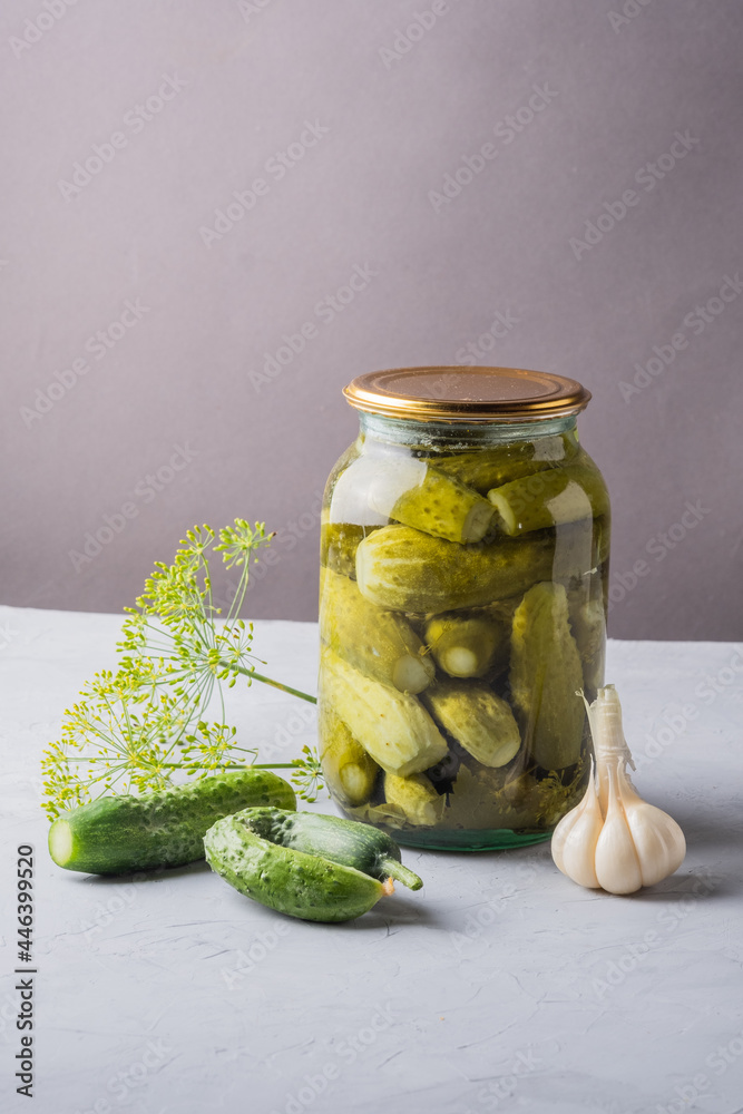 Pickled cucumbers in the jar. Ingredients for pickling cucumbers. Cucumbers, dill, garlic. Glass jars with pickles Pickled cucumbers in the jar. Ingredients for pickling cucumbers. Cucumbers, dill, garlic. Glass jars with pickles