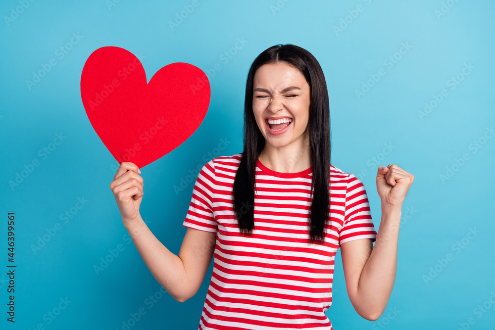 Photo of young girl happy smile hold big heart rejoice victory lucky success isolated over blue color background Photo of young girl happy smile hold big heart rejoice victory lucky success isolated over blue color background