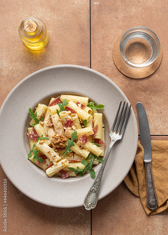 Dish of pasta with arugula, salami and walnuts Dish of pasta with arugula, salami and walnuts