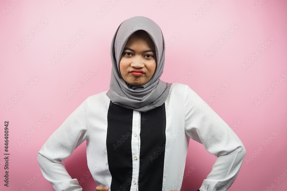 Beautiful young asian muslim woman pouting, angry, feeling annoyed, dissatisfied, uncomfortable, feeling bullied, lied to, looking at camera isolated on pink background