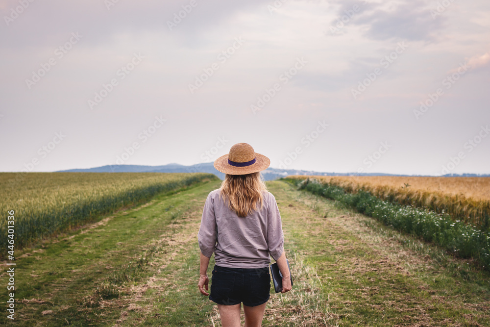 Farmer inspecting and examining agricultural field with cereal plant. Woman with straw hat and digital tablet walking in her organic farm Farmer inspecting and examining agricultural field with cereal plant. Woman with straw hat and digital tablet walking in her organic farm